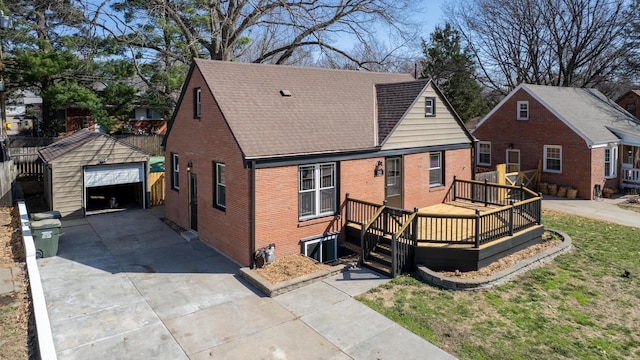 3772 F St, Lincoln, NE 68510 - view of front of home featuring an outdoor structure, a deck, brick siding, a garage, and driveway