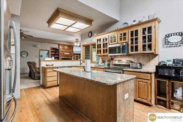 3521 N 267th Plz, Waterloo, NE 68069 - kitchen featuring stainless steel appliances, a ceiling fan, a center island, a peninsula, and light wood-style flooring