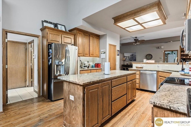 3521 N 267th Plz, Waterloo, NE 68069 - kitchen with appliances with stainless steel finishes, light wood finished floors, ceiling fan, a center island, and a peninsula