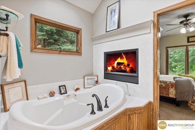3521 N 267th Plz, Waterloo, NE 68069 - bathroom featuring a garden tub, connected bathroom, a ceiling fan, and a fireplace
