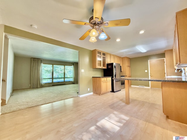 1254 N 8th St, Seward, NE 68434 - kitchen with freestanding refrigerator, light wood-type flooring, glass insert cabinets, ceiling fan, and open floor plan