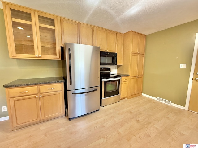 1254 N 8th St, Seward, NE 68434 - kitchen featuring appliances with stainless steel finishes, light wood-style flooring, glass insert cabinets, a textured ceiling, and light brown cabinetry