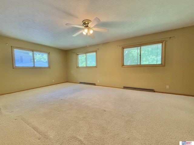1254 N 8th St, Seward, NE 68434 - spare room with a baseboard radiator, a ceiling fan, a baseboard heating unit, and carpet flooring