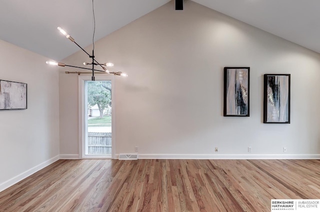 2726 N 129th Cir, Omaha, NE 68164 - unfurnished room featuring a chandelier, high vaulted ceiling, and wood finished floors