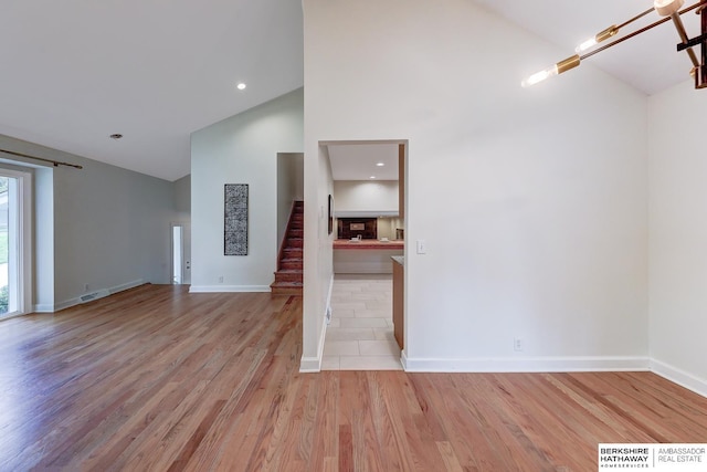 2726 N 129th Cir, Omaha, NE 68164 - unfurnished living room featuring high vaulted ceiling, wood finished floors, stairs, and recessed lighting