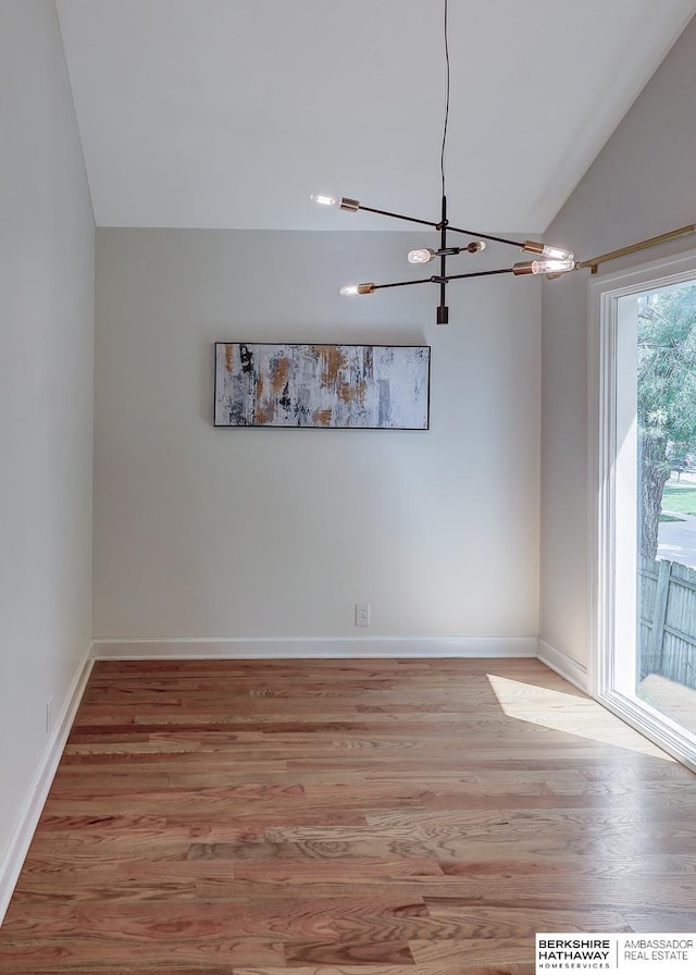 2726 N 129th Cir, Omaha, NE 68164 - empty room with a chandelier, vaulted ceiling, and light wood finished floors