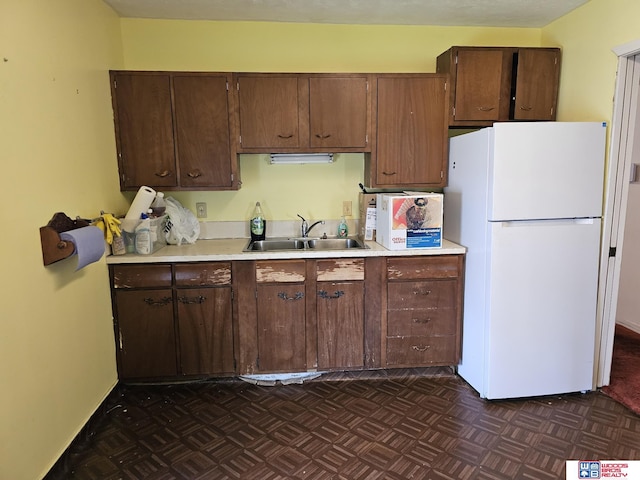 2627 Garfield St, Lincoln, NE 68502 - kitchen featuring freestanding refrigerator, light countertops, and dark brown cabinetry