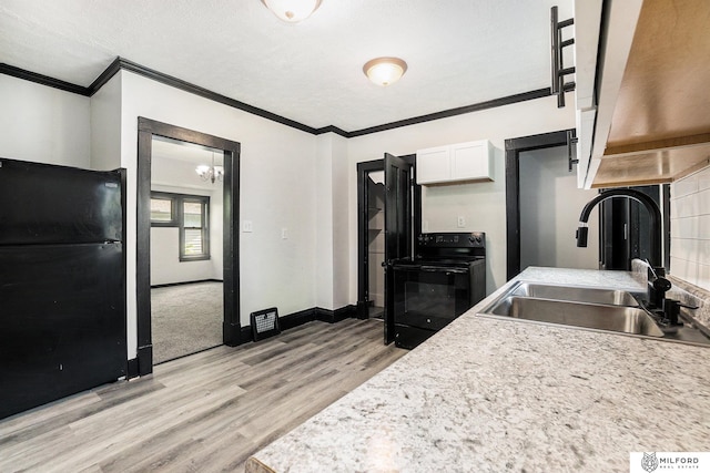 4419 N 39th St, Omaha, NE 68111 - kitchen featuring black appliances, crown molding, light wood-style floors, white cabinets, and light countertops