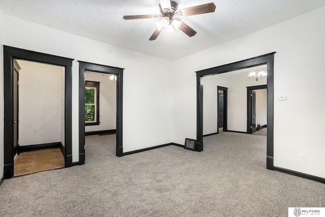 4419 N 39th St, Omaha, NE 68111 - unfurnished room with light colored carpet, a textured ceiling, a ceiling fan, and a chandelier