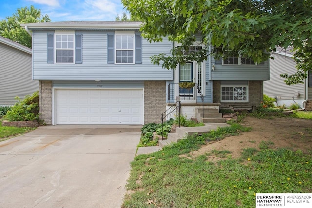 17737 Edna St, Omaha, NE 68136 - split foyer home with an attached garage, concrete driveway, and brick siding