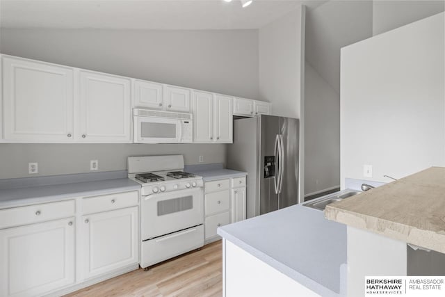 17737 Edna St, Omaha, NE 68136 - kitchen featuring white appliances, vaulted ceiling, white cabinetry, light wood-style flooring, and light countertops