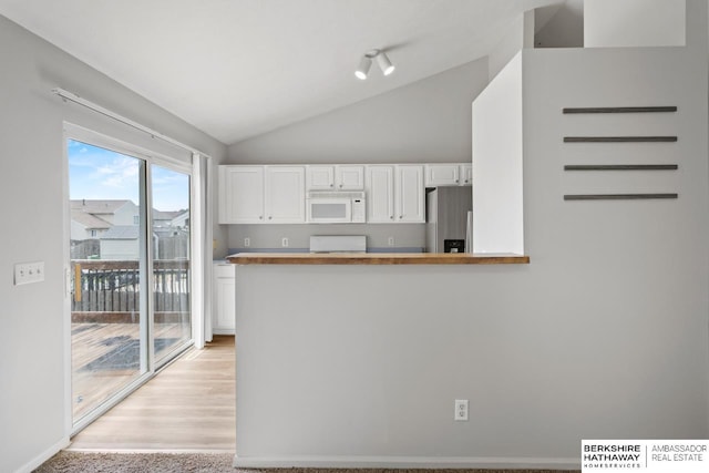 17737 Edna St, Omaha, NE 68136 - kitchen featuring white microwave, stainless steel refrigerator with ice dispenser, white cabinets, lofted ceiling, and range