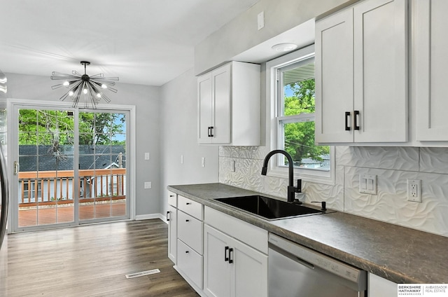3080 S 48th St, Omaha, NE 68106 - kitchen featuring dishwasher, dark countertops, tasteful backsplash, a chandelier, and white cabinetry