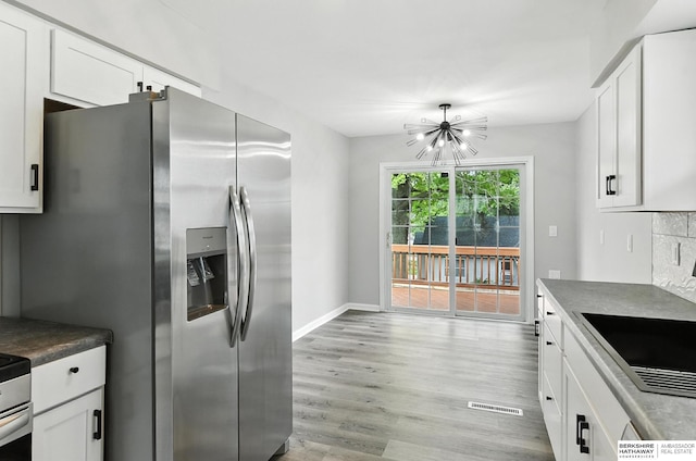 3080 S 48th St, Omaha, NE 68106 - kitchen with stainless steel refrigerator with ice dispenser, a chandelier, light wood-style floors, and white cabinetry