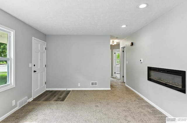 3080 S 48th St, Omaha, NE 68106 - carpeted foyer featuring a glass covered fireplace, recessed lighting, and a textured ceiling
