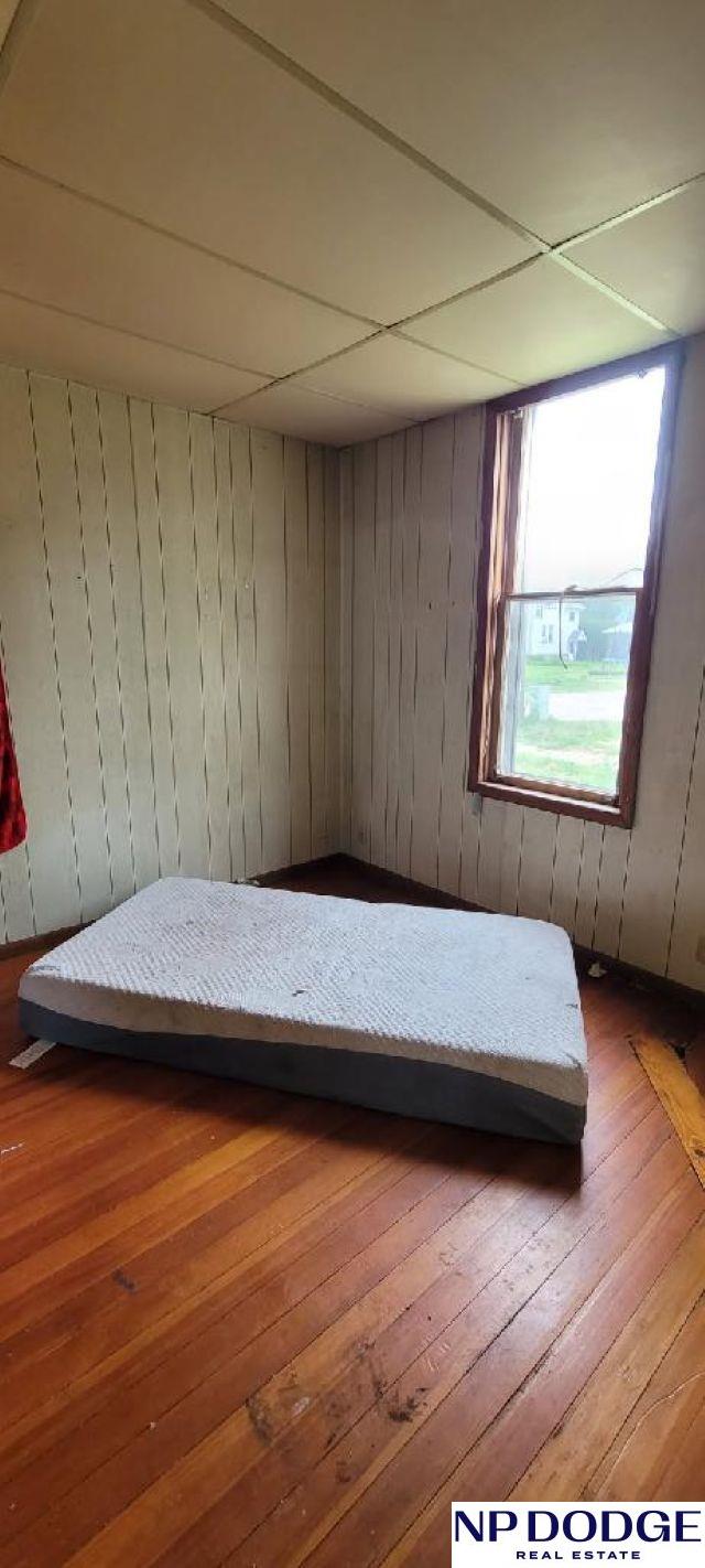 609 Howard St, Scribner, NE 68057 - bedroom featuring hardwood / wood-style floors and wood walls