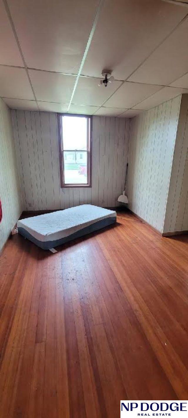 609 Howard St, Scribner, NE 68057 - unfurnished bedroom featuring hardwood / wood-style flooring and a drop ceiling