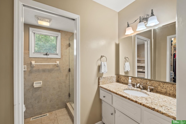 411 Hillside Ave, Yutan, NE 68073 - bathroom with a spacious closet, vanity, tile patterned flooring, and a stall shower