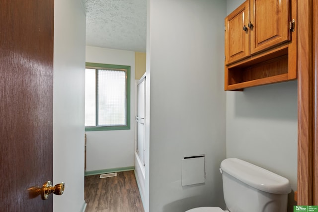 36 Redwood Ln, Yutan, NE 68073 - full bathroom with wood finished floors, a shower with shower door, and a textured ceiling