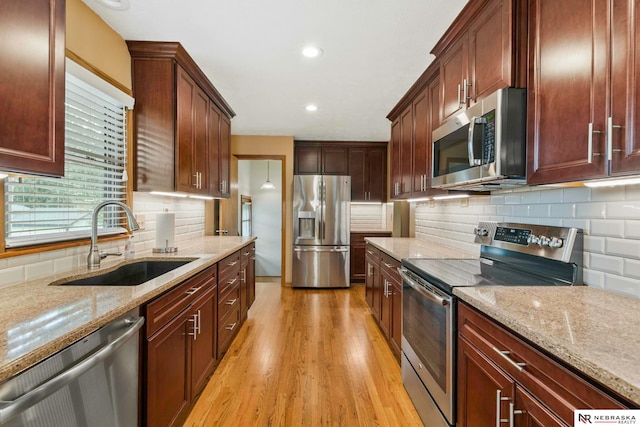 11018 Hascall St, Omaha, NE 68144 - kitchen with stainless steel appliances, light wood-style flooring, light stone counters, tasteful backsplash, and recessed lighting
