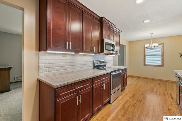 11018 Hascall St, Omaha, NE 68144 - kitchen featuring appliances with stainless steel finishes, a chandelier, recessed lighting, tasteful backsplash, and decorative light fixtures