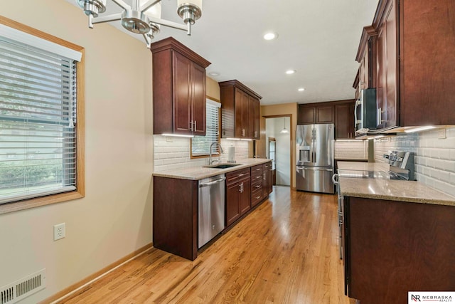 11018 Hascall St, Omaha, NE 68144 - kitchen featuring stainless steel appliances, decorative backsplash, light wood finished floors, light stone counters, and recessed lighting