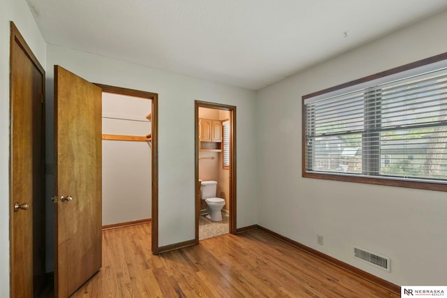 11018 Hascall St, Omaha, NE 68144 - unfurnished bedroom featuring a closet, a spacious closet, light wood-type flooring, and connected bathroom