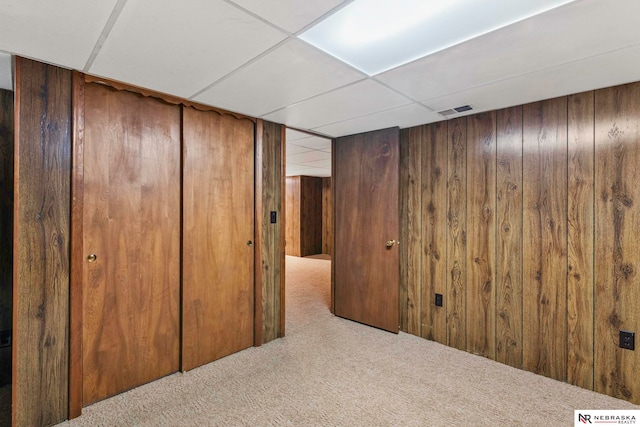 11018 Hascall St, Omaha, NE 68144 - finished basement with wood walls, carpet flooring, and a paneled ceiling