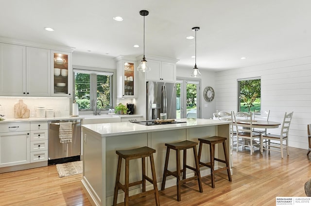 9903 Pasadena Ave, Omaha, NE 68124 - kitchen with appliances with stainless steel finishes, healthy amount of natural light, light wood finished floors, white cabinets, and recessed lighting