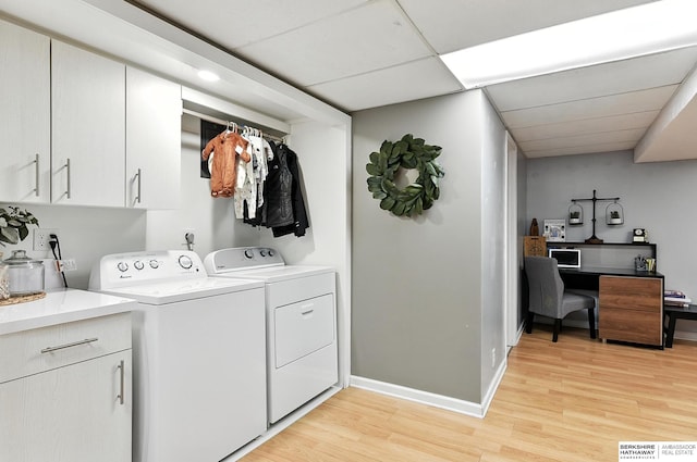 9903 Pasadena Ave, Omaha, NE 68124 - washroom featuring washer and clothes dryer, light wood-style flooring, and cabinet space