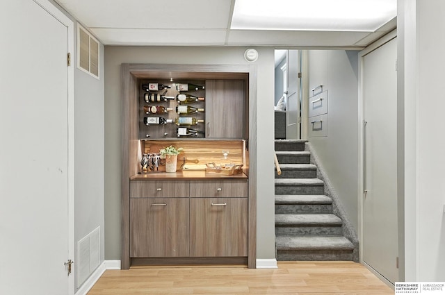 9903 Pasadena Ave, Omaha, NE 68124 - indoor bar featuring light wood-type flooring and stairs