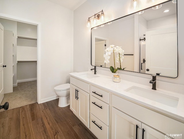 1070 Titan Dr, Hickman, NE 68372 - bathroom with wood finished floors, double vanity, and a spacious closet