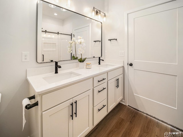 1070 Titan Dr, Hickman, NE 68372 - bathroom featuring wood finished floors, double vanity, and an enclosed shower