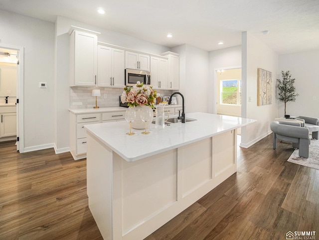 1070 Titan Dr, Hickman, NE 68372 - kitchen featuring stainless steel microwave, dark wood-type flooring, white cabinetry, decorative backsplash, and recessed lighting
