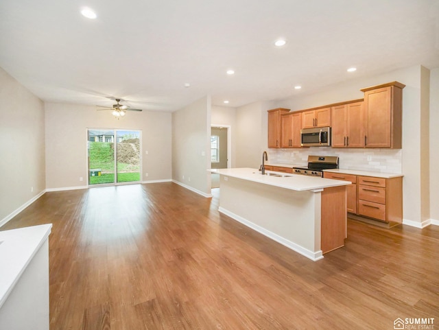 1120 Titan Dr, Hickman, NE 68372 - kitchen with appliances with stainless steel finishes, a center island with sink, open floor plan, a ceiling fan, and light countertops