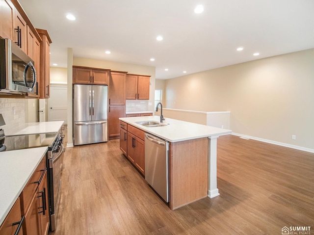 1120 Titan Dr, Hickman, NE 68372 - kitchen featuring appliances with stainless steel finishes, light wood-style flooring, tasteful backsplash, light countertops, and brown cabinets