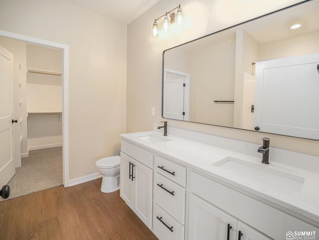 1130 Titan Dr, Hickman, NE 68372 - full bathroom with double vanity, wood finished floors, recessed lighting, and a walk in closet