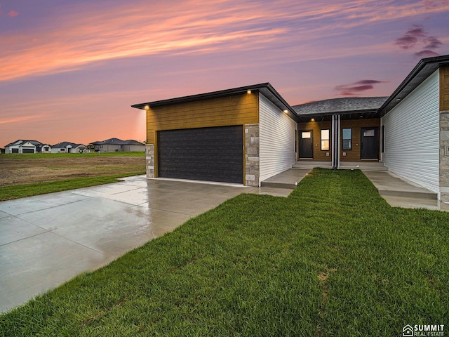 1130 Titan Dr, Hickman, NE 68372 - contemporary home with an attached garage, a front lawn, stone siding, and concrete driveway