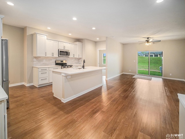 1130 Titan Dr, Hickman, NE 68372 - kitchen with appliances with stainless steel finishes, a ceiling fan, decorative backsplash, dark wood-type flooring, and recessed lighting