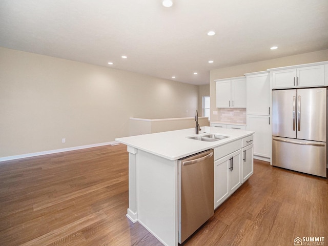 1130 Titan Dr, Hickman, NE 68372 - kitchen with appliances with stainless steel finishes, an island with sink, light wood-style flooring, white cabinetry, and light countertops