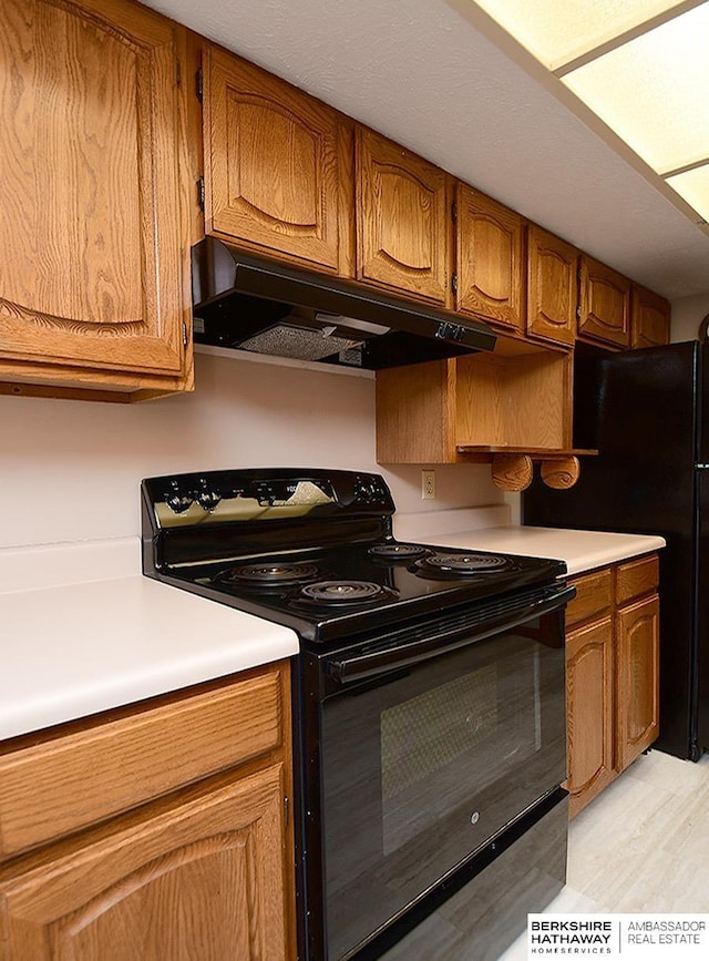 1502 Sunshine Blvd, Bellevue, NE 68123 - kitchen with electric range, under cabinet range hood, light countertops, and brown cabinets