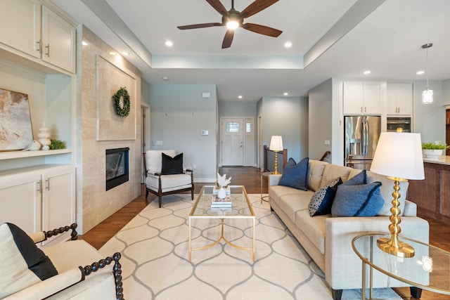 1320 S 190th Plz, Omaha, NE 68130 - living room with light wood-style floors, a fireplace, ceiling fan, recessed lighting, and a raised ceiling