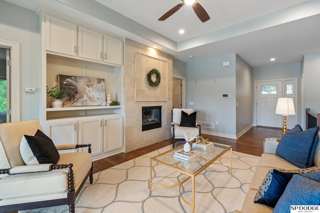 1320 S 190th Plz, Omaha, NE 68130 - living room featuring a tiled fireplace, dark wood-type flooring, a ceiling fan, and recessed lighting