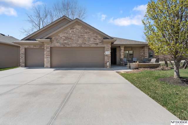 1320 S 190th Plz, Omaha, NE 68130 - view of front of house featuring a garage, driveway, a front yard, stone siding, and ceiling fan