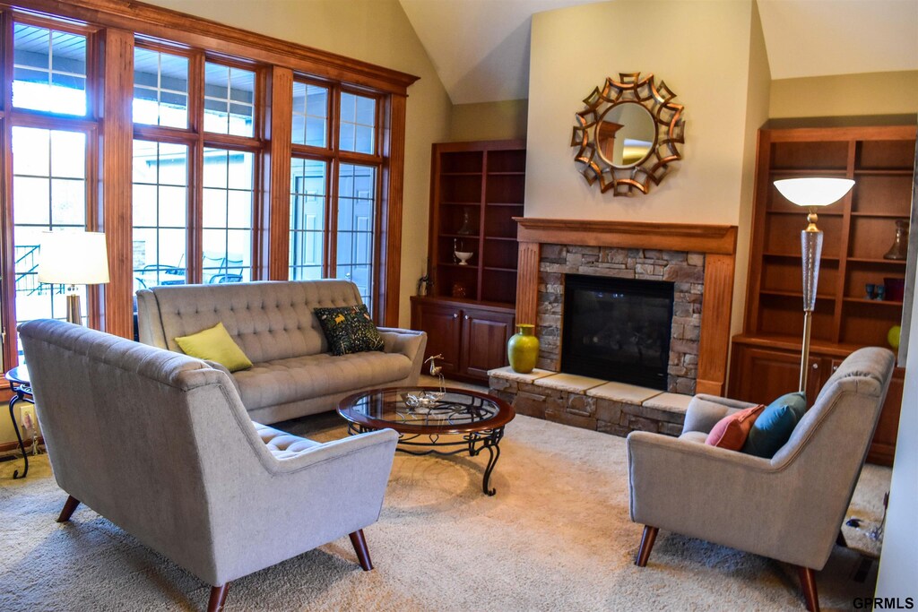 7841 Preserve Ln, Lincoln, NE 68516 - living area featuring vaulted ceiling, carpet floors, and a stone fireplace