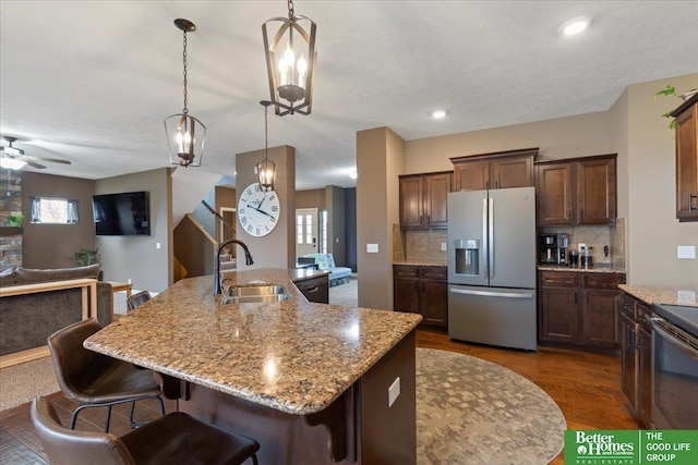 14611 S 24th St, Bellevue, NE 68123 - kitchen with appliances with stainless steel finishes, open floor plan, decorative backsplash, light stone countertops, and a kitchen breakfast bar