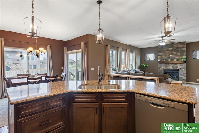 14611 S 24th St, Bellevue, NE 68123 - kitchen with stainless steel dishwasher, a ceiling fan, a fireplace, open floor plan, and hanging light fixtures