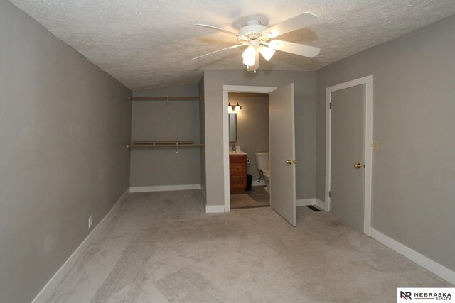 4300 N St, Lincoln, NE 68510 - unfurnished bedroom with a textured ceiling, light carpet, ceiling fan, and ensuite bath