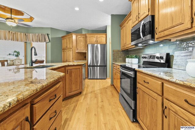 16367 Y St, Omaha, NE 68135 - kitchen with appliances with stainless steel finishes, light wood-type flooring, a ceiling fan, light stone countertops, and tasteful backsplash