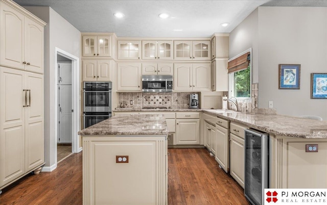 733 N 157th Cir, Omaha, NE 68118 - kitchen with stainless steel appliances, beverage cooler, decorative backsplash, glass insert cabinets, and recessed lighting